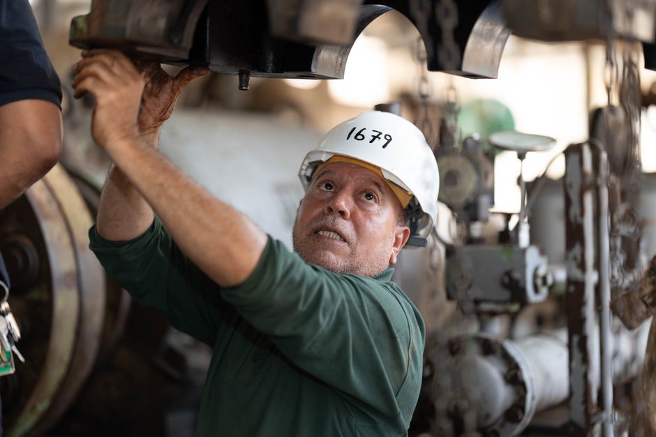 Técnico de mantenimiento industrial revisando maquinaria en una planta